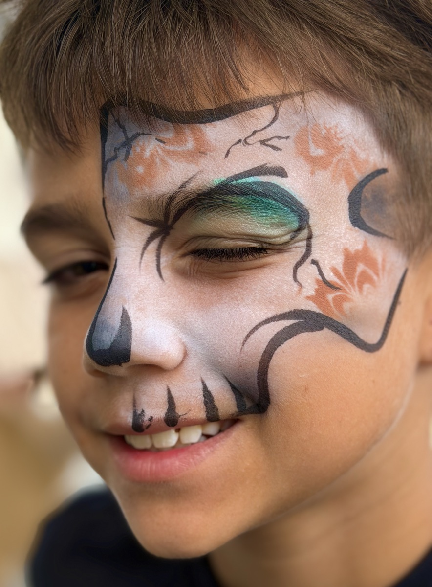 Boy with a sugar skull design, painted eye closed