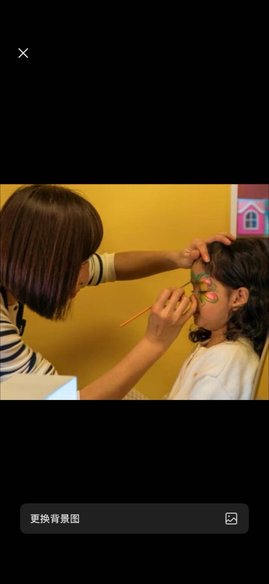 Yang painting a butterfly design on a child's face